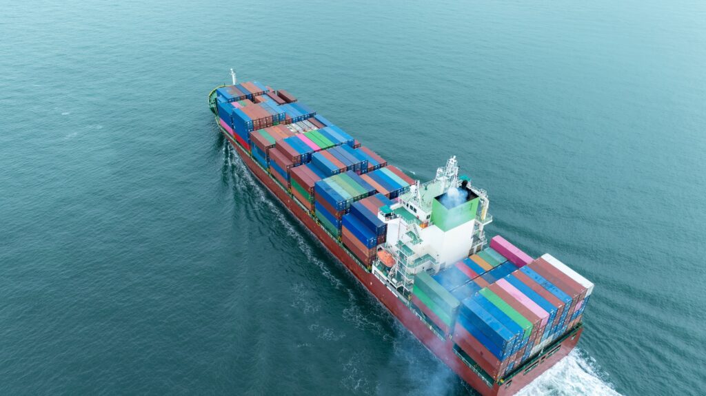 Cargo container ship carrying container and running in the ocean near international container